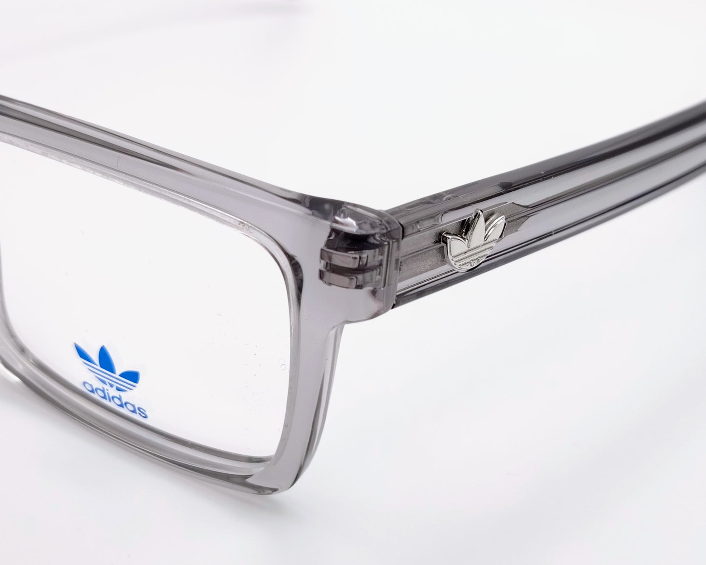 adidas or5107 020 gafas de vista con montura rectangular en acetato transparente gris diseño moderno con varillas decoradas con líneas en relieve y el icónico logo trefoil en metal estructura ligera y versátil