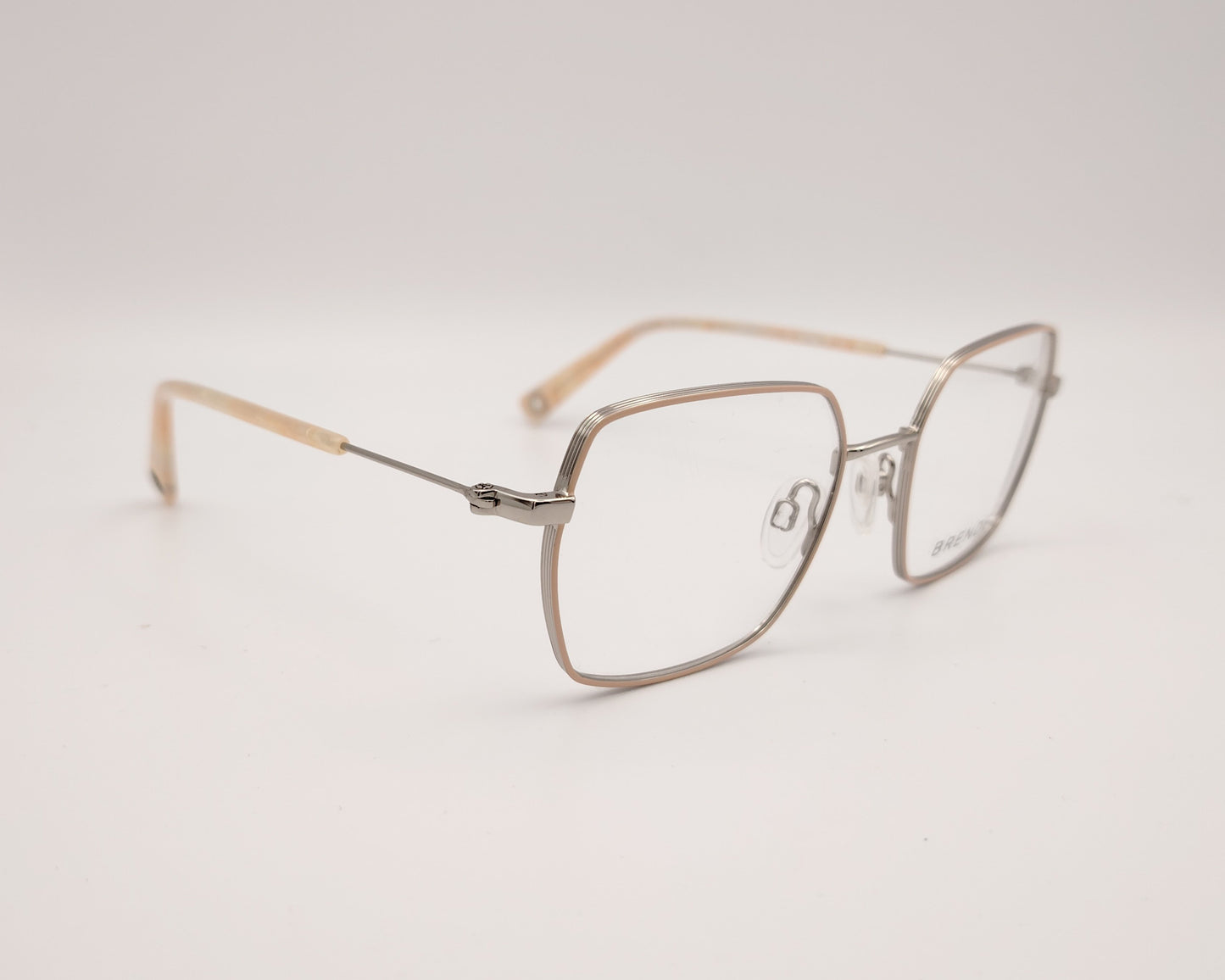 gafas graduadas con montura metálica fina, forma cuadrada ligeramente redondeada y terminales en beige nacarado