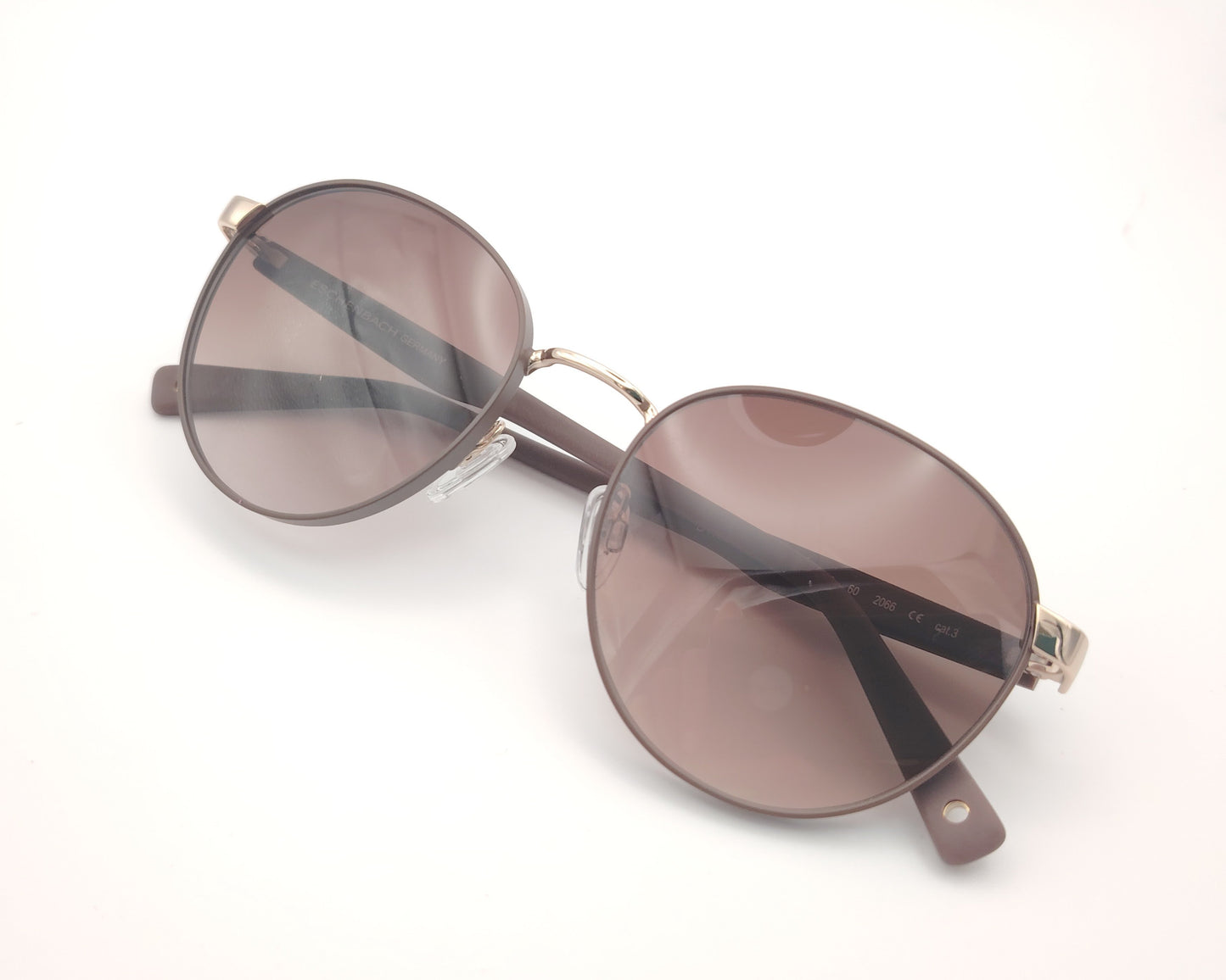 gafas de sol redondas con montura marrón y detalles dorados en los talones