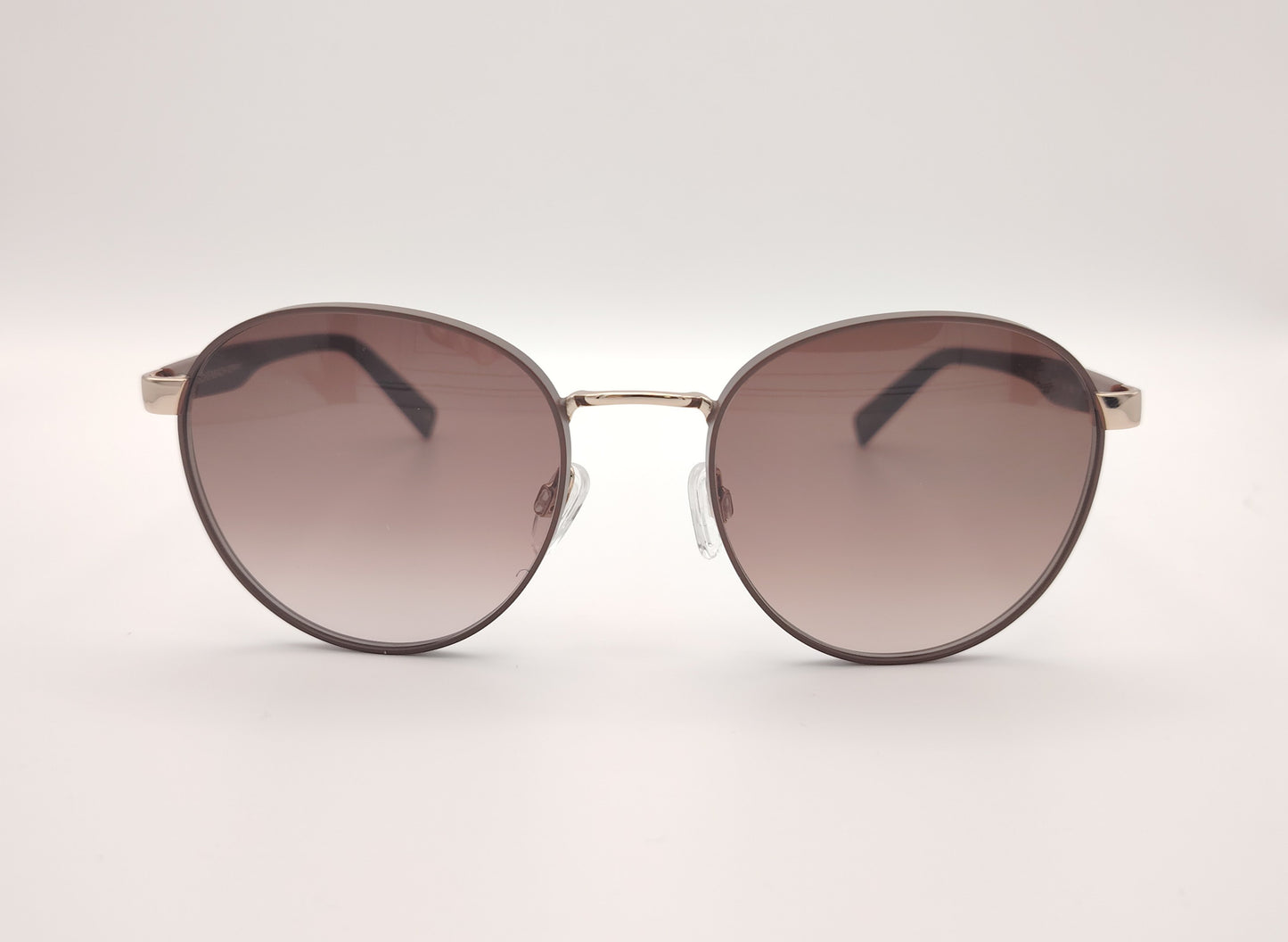 gafas de sol redondas con montura marrón y detalles dorados en los talones