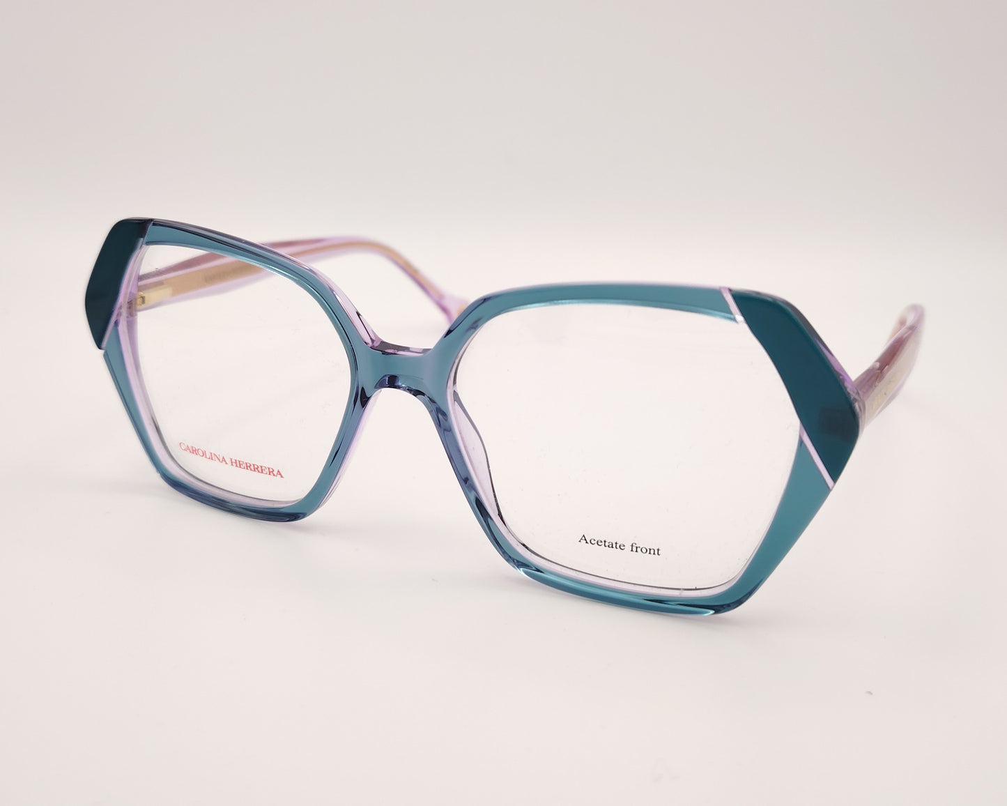 gafas graduadas con montura geométrica en tonos morado y verde agua, varillas rosadas y logo dorado de carolina herrera