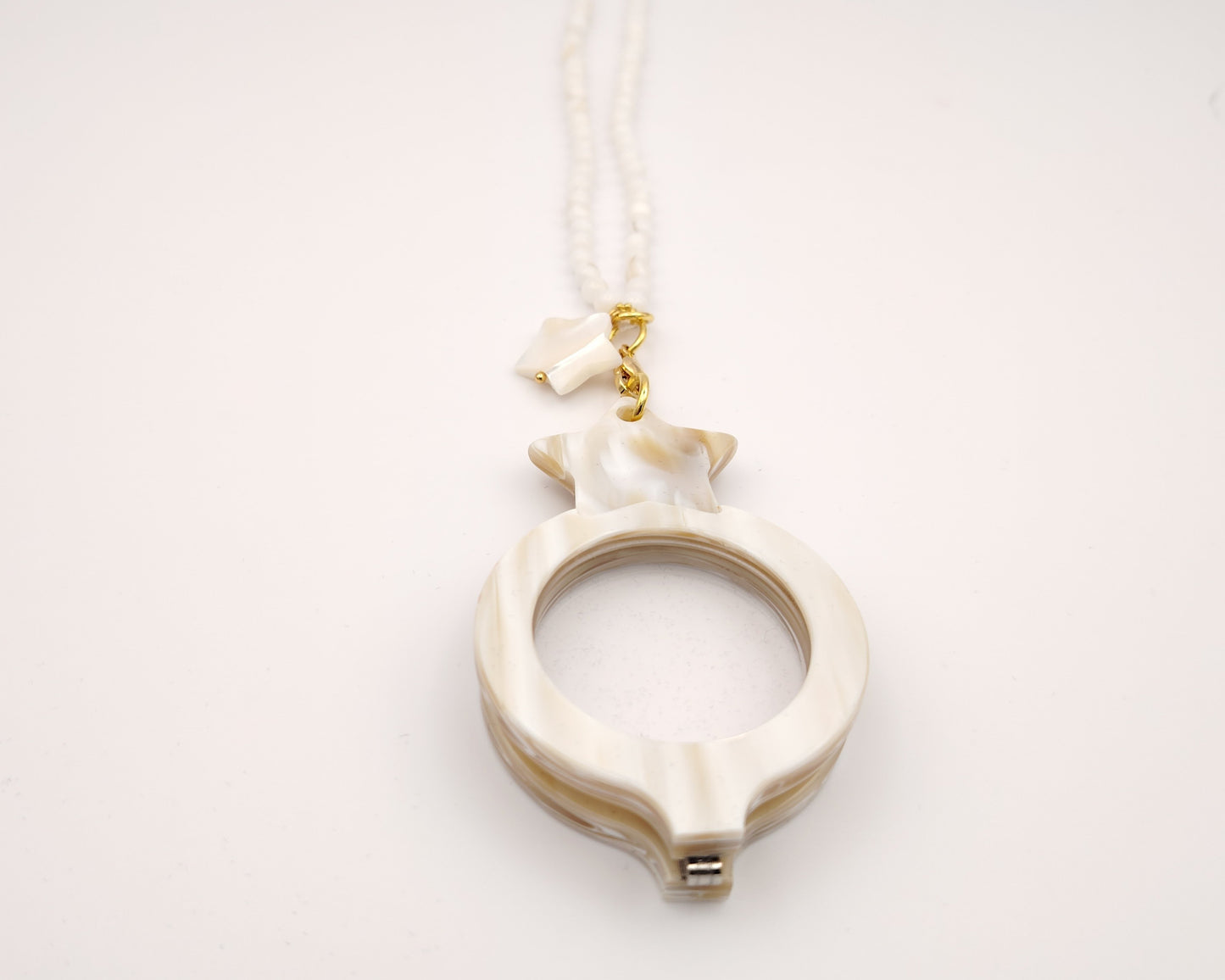 colgante lupa doble plegable en forma de ocho con acabado nácar y estrella decorativa