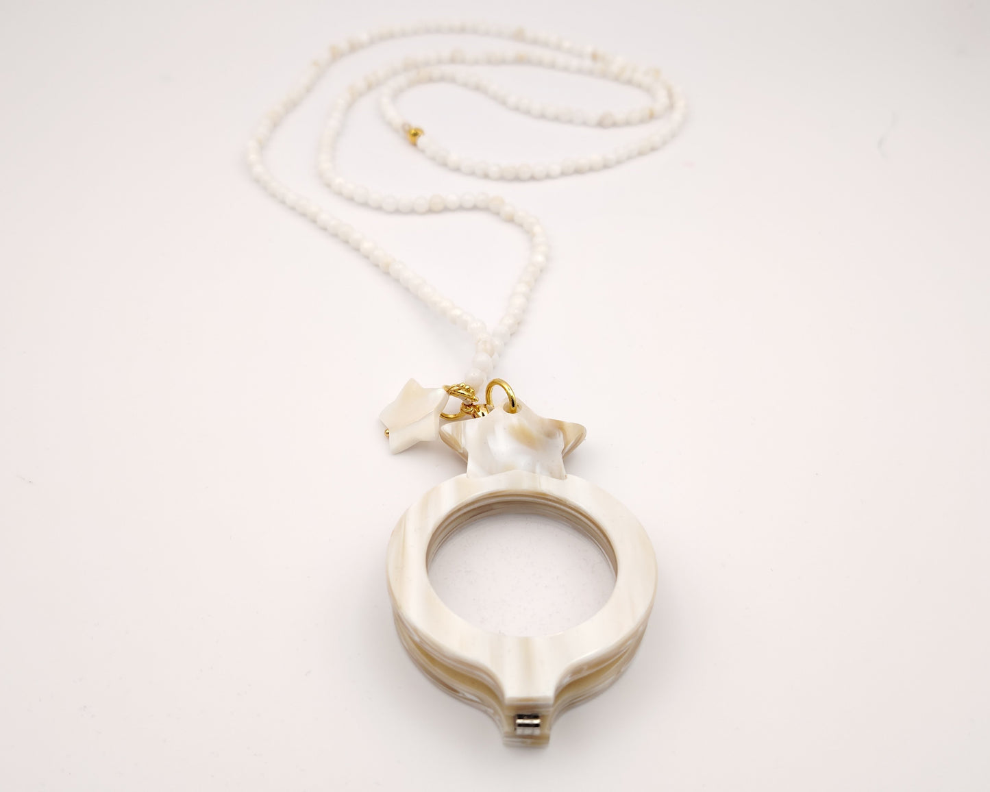colgante lupa doble plegable en forma de ocho con acabado nácar y estrella decorativa