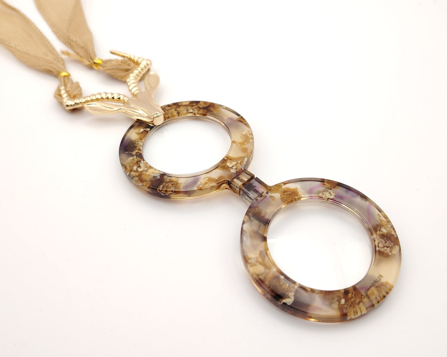 ente de lectura plegable flippan look con diseño jaspeado en tonos tierra y colgante de antílope dorado y cinta para colgar en gasa nude