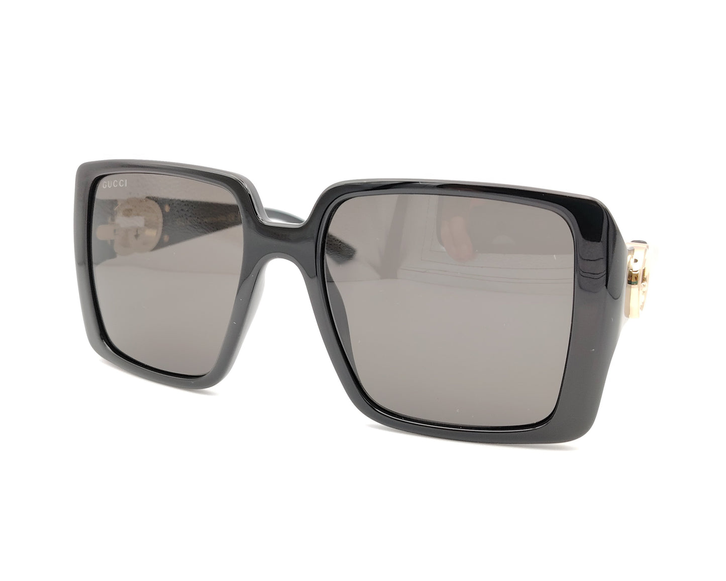 gafas de sol negras grandes con forma cuadrada y logo dorado en las patillas