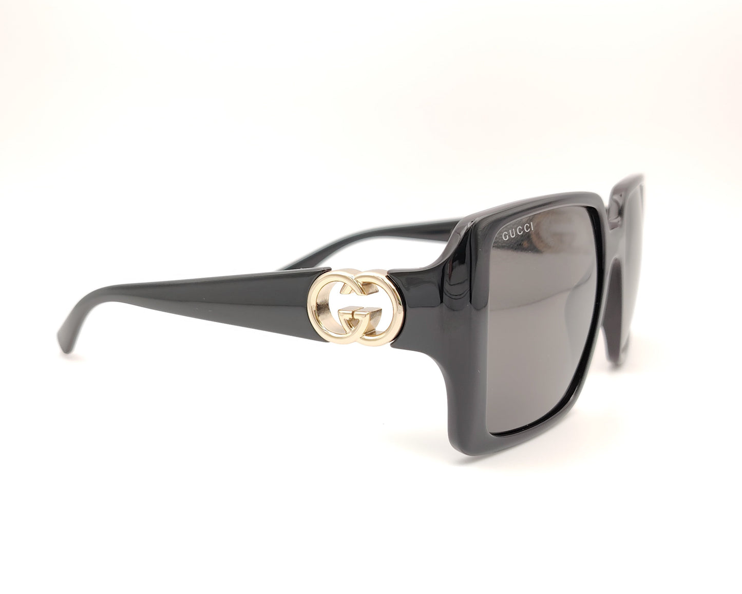 gafas de sol negras grandes con forma cuadrada y logo dorado en las patillas