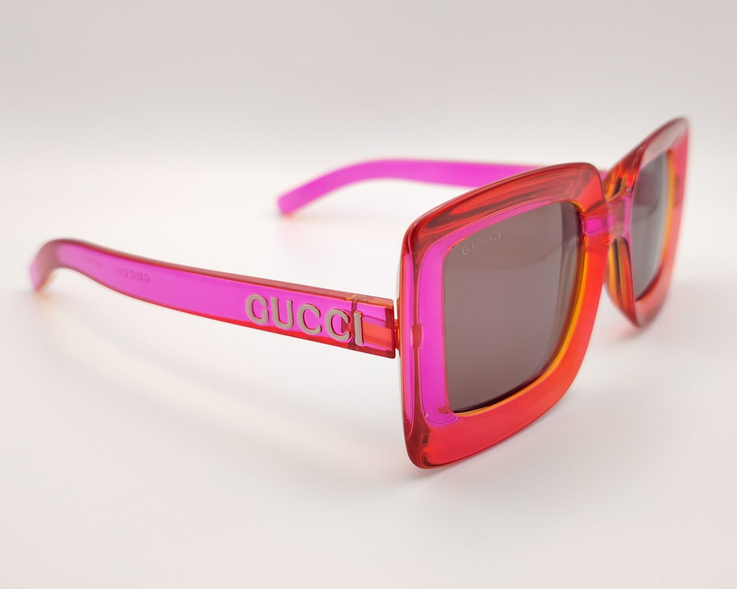 gafas de sol gucci gg1718s con montura gruesa en tonos rojo y rosa translúcido y lentes ahumadas