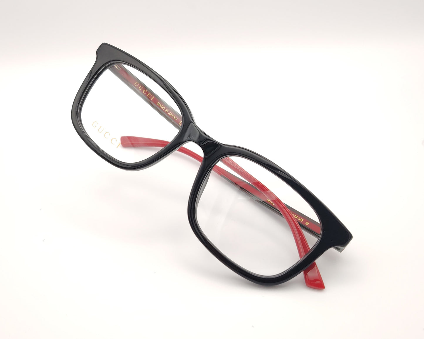 gafas gucci de pasta negra y varillas en rojo y verde con logo dorado