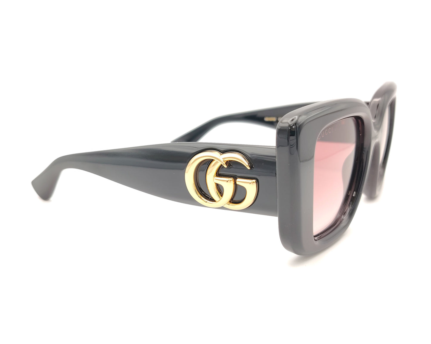 gafas de sol gucci negras con lentes rosa degradado y logo gg dorado en las varillas