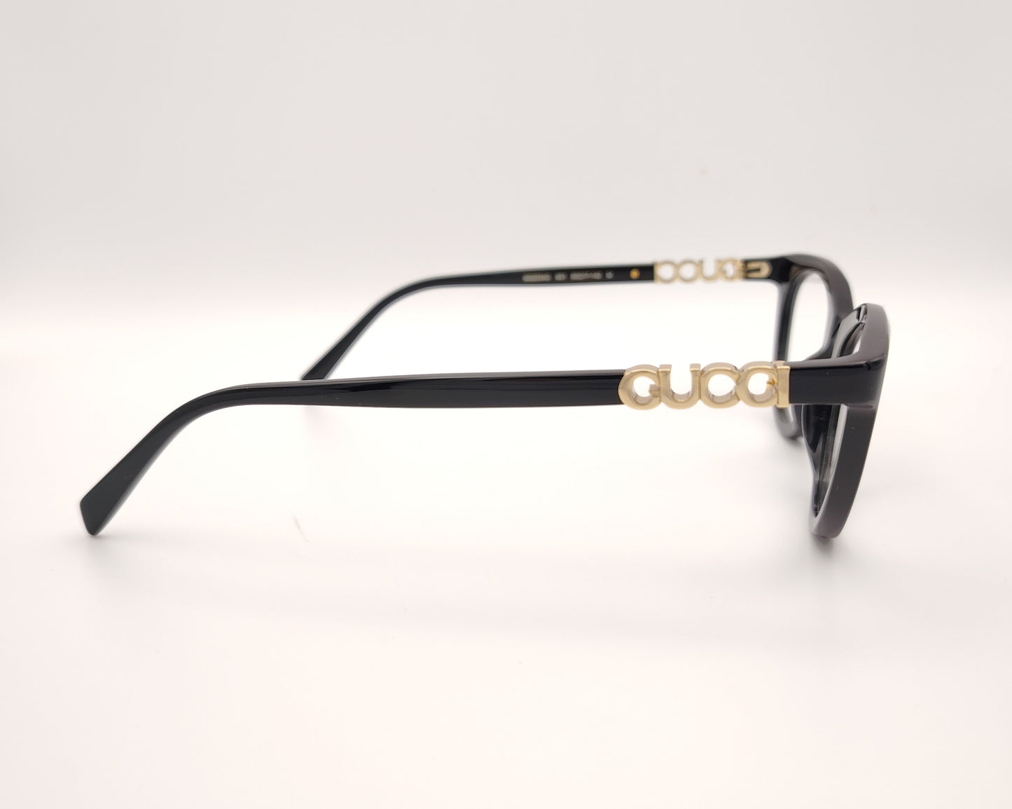 gafas gucci negras redondeadas con logo dorado en varilla
