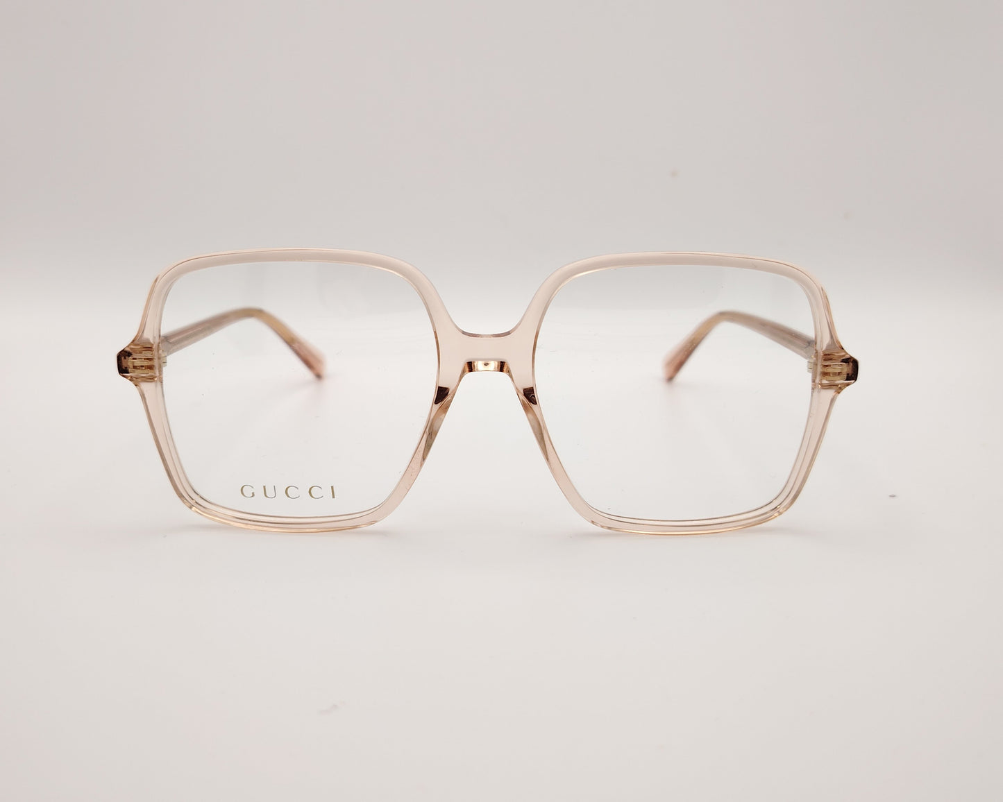 gafas graduadas de oversize con montura cuadrada en tono rosa claro translúcido y logotipo gucci en la lente izquierda