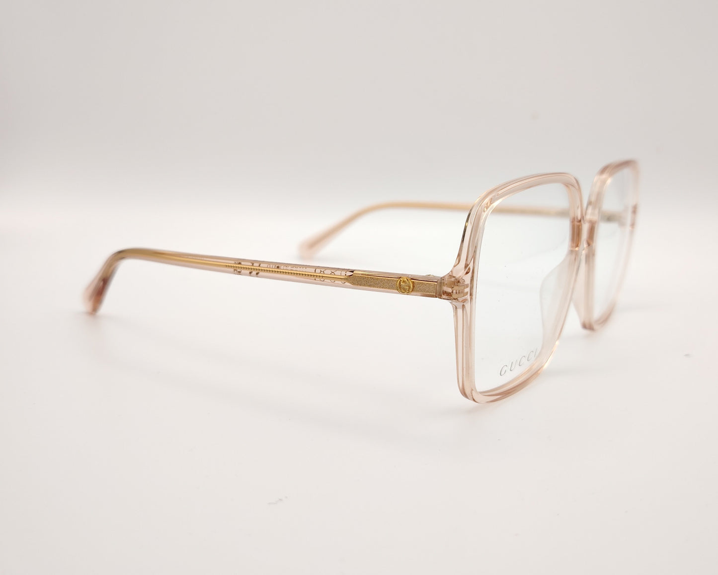 gafas graduadas de oversize con montura cuadrada en tono rosa claro translúcido y logotipo gucci en la lente izquierda