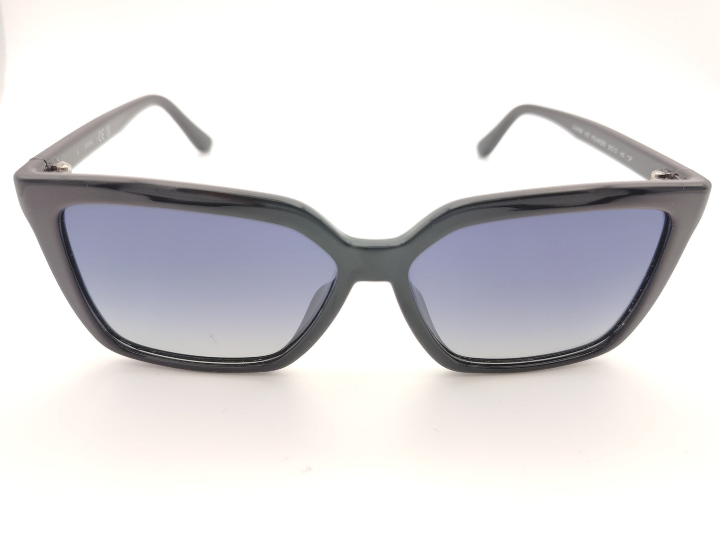 gafas de sol negras con montura en forma cuadrada, cristales degradados en tonos azulados y detalles dorados con símbolos decorativos en la varilla