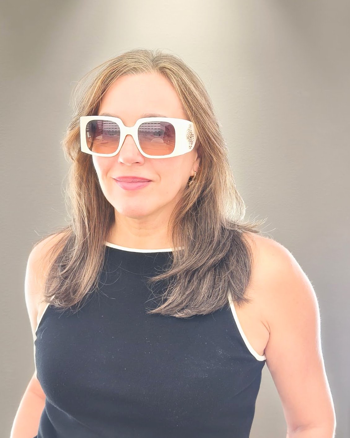 gafas de sol grandes con montura blanca rectangular, lentes degradadas en lila y detalle decorativo en las varillas