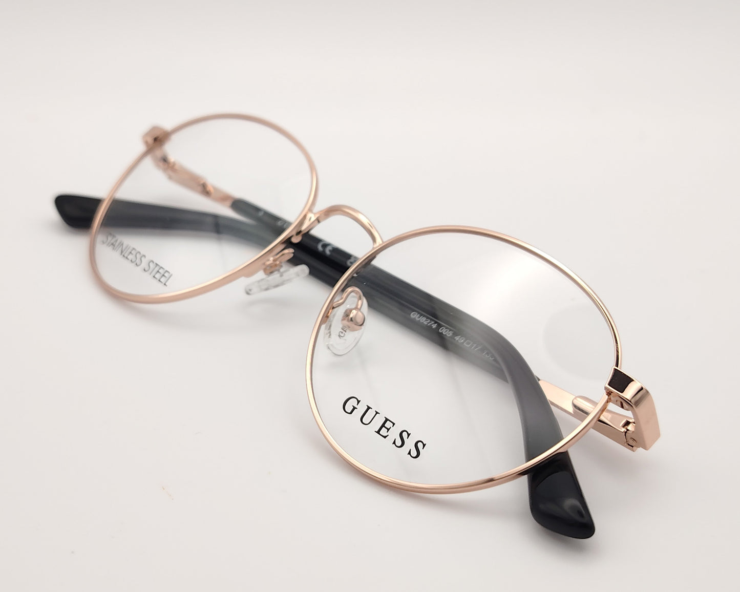 gafas guess gu8274 005, montura metálica en color oro rosa, diseño ovalado con varillas negras y plaquetas ajustables, estilo elegante y moderno