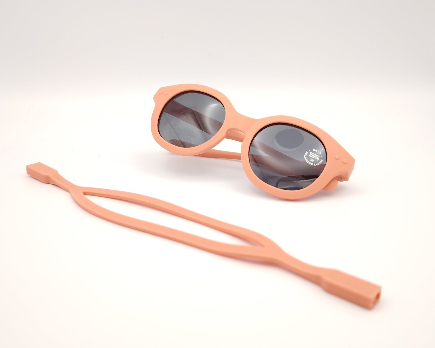 gafas de sol para niños izipizi de pasta redondas en color salmón con cinta para sujetar a juego