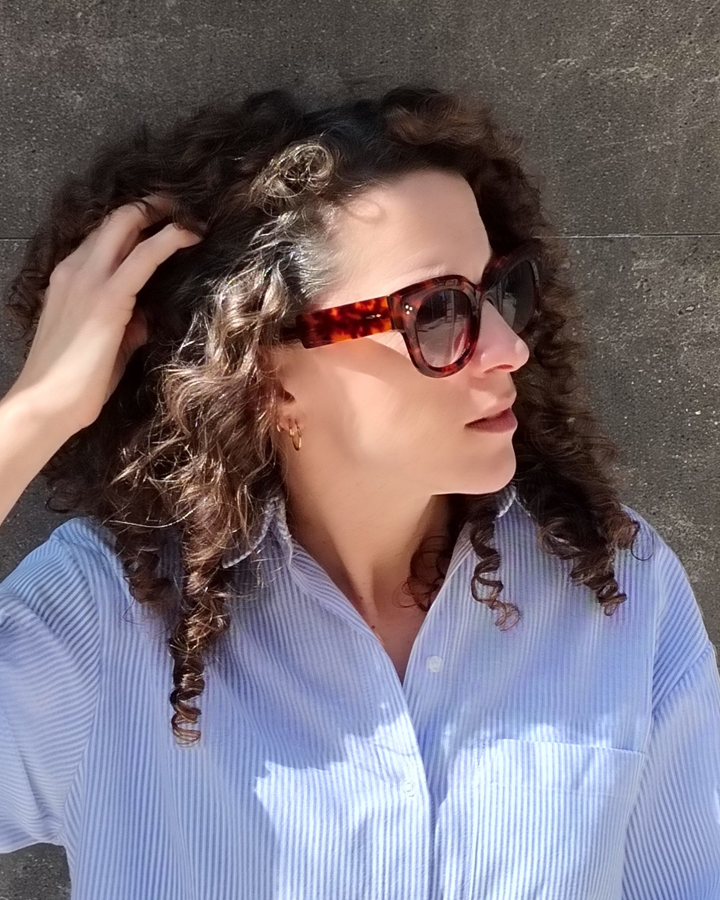 persona con gafas de sol carey de montura gruesa y lentes degradadas