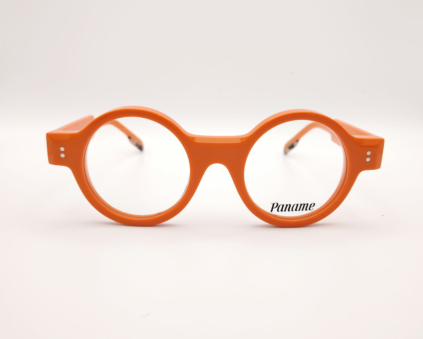 gafas redondas de acetato naranja con detalle dorado en la patilla y frontal grueso