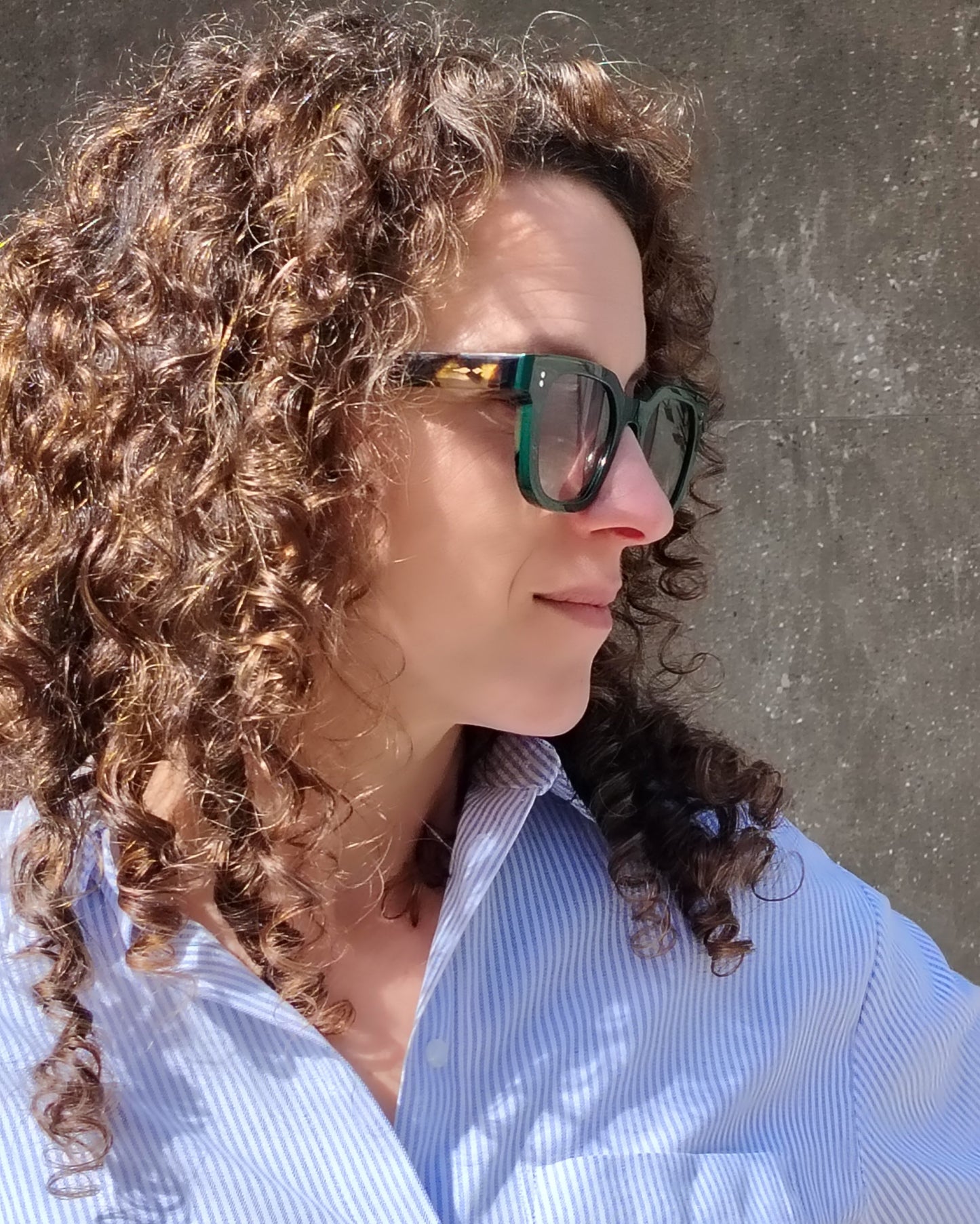 persona con gafas de sol verde oscuro con varillas carey y lentes degradadas