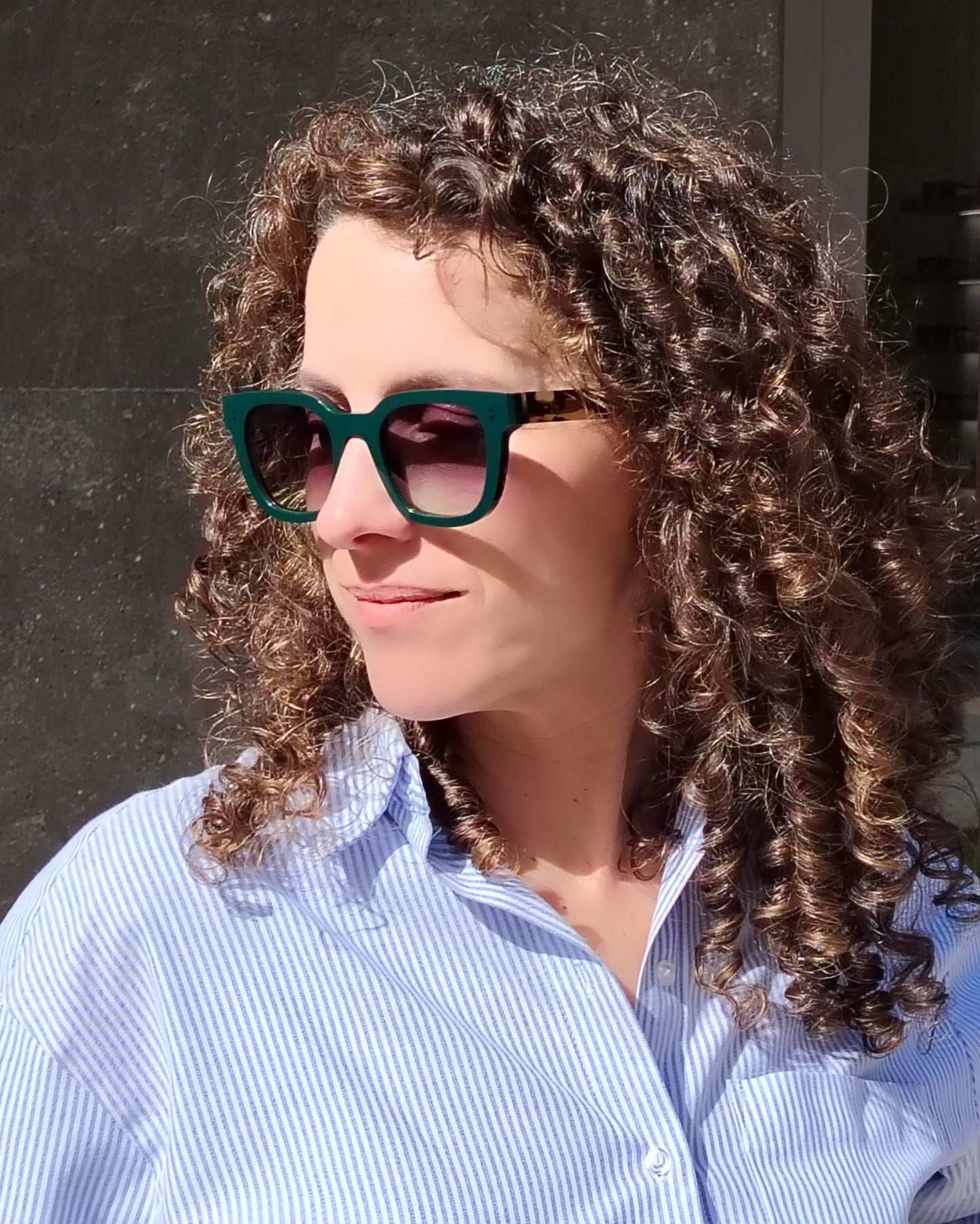 persona con gafas de sol verde oscuro con varillas carey y lentes degradadas