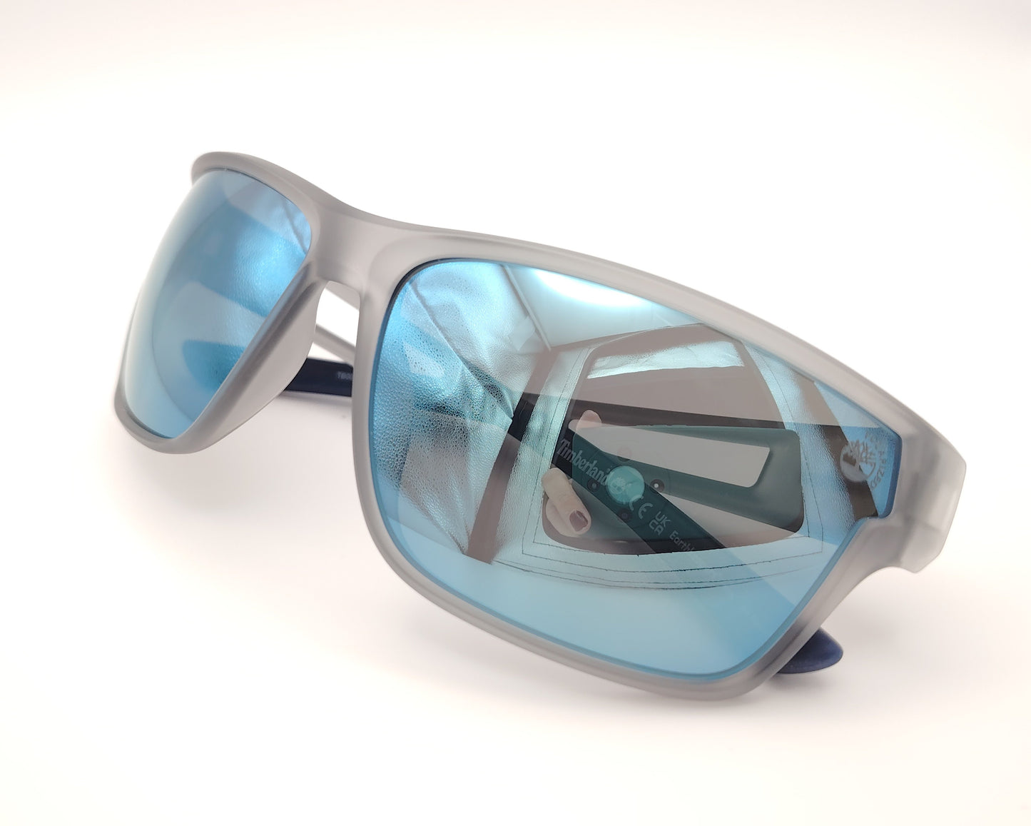 gafas de sol deportivas con montura gris translúcida y lentes espejo azules