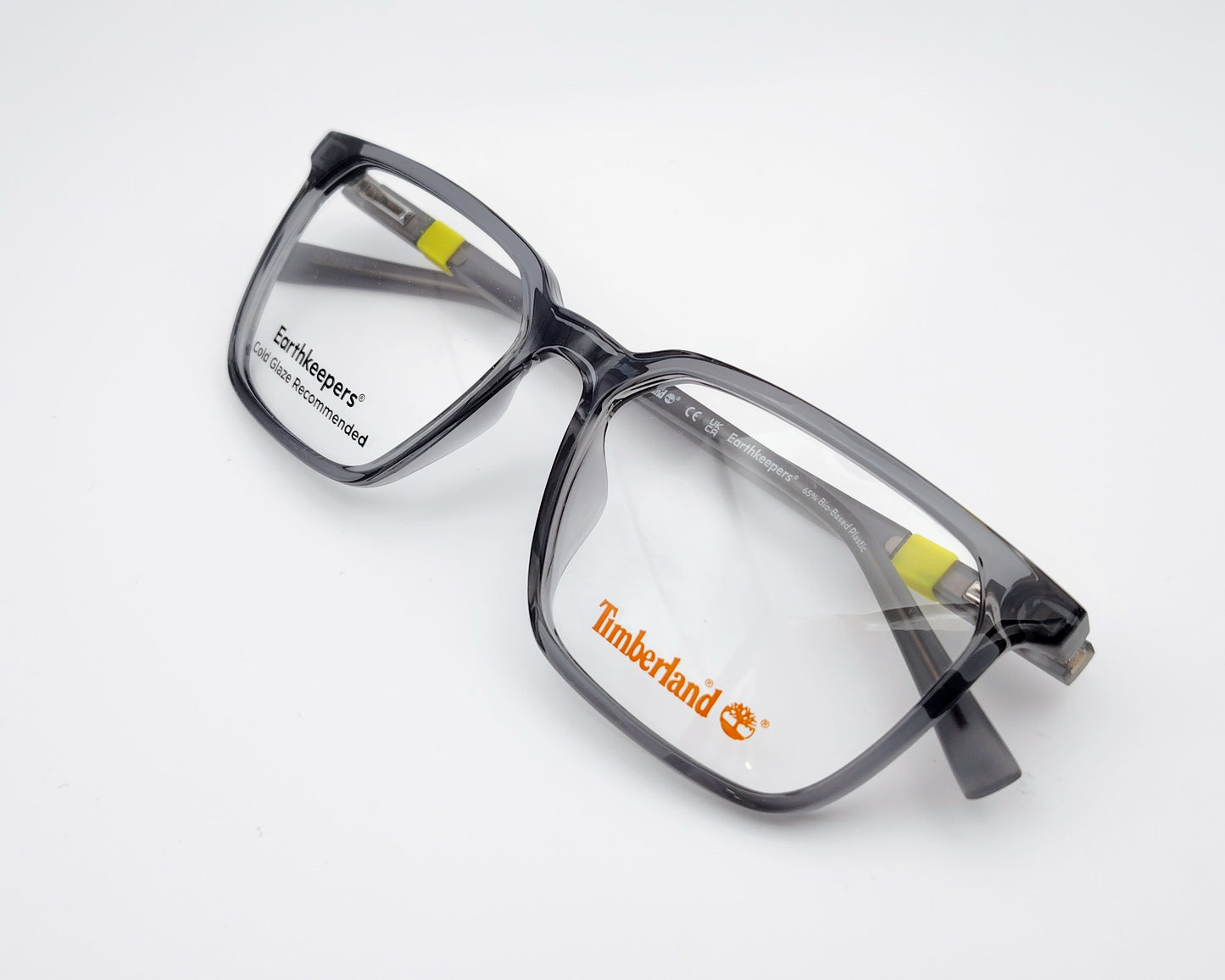 gafas en formato cuadrado de acetato en color gris traslúcido con detalle de logo en amarillo neón en las varillas
