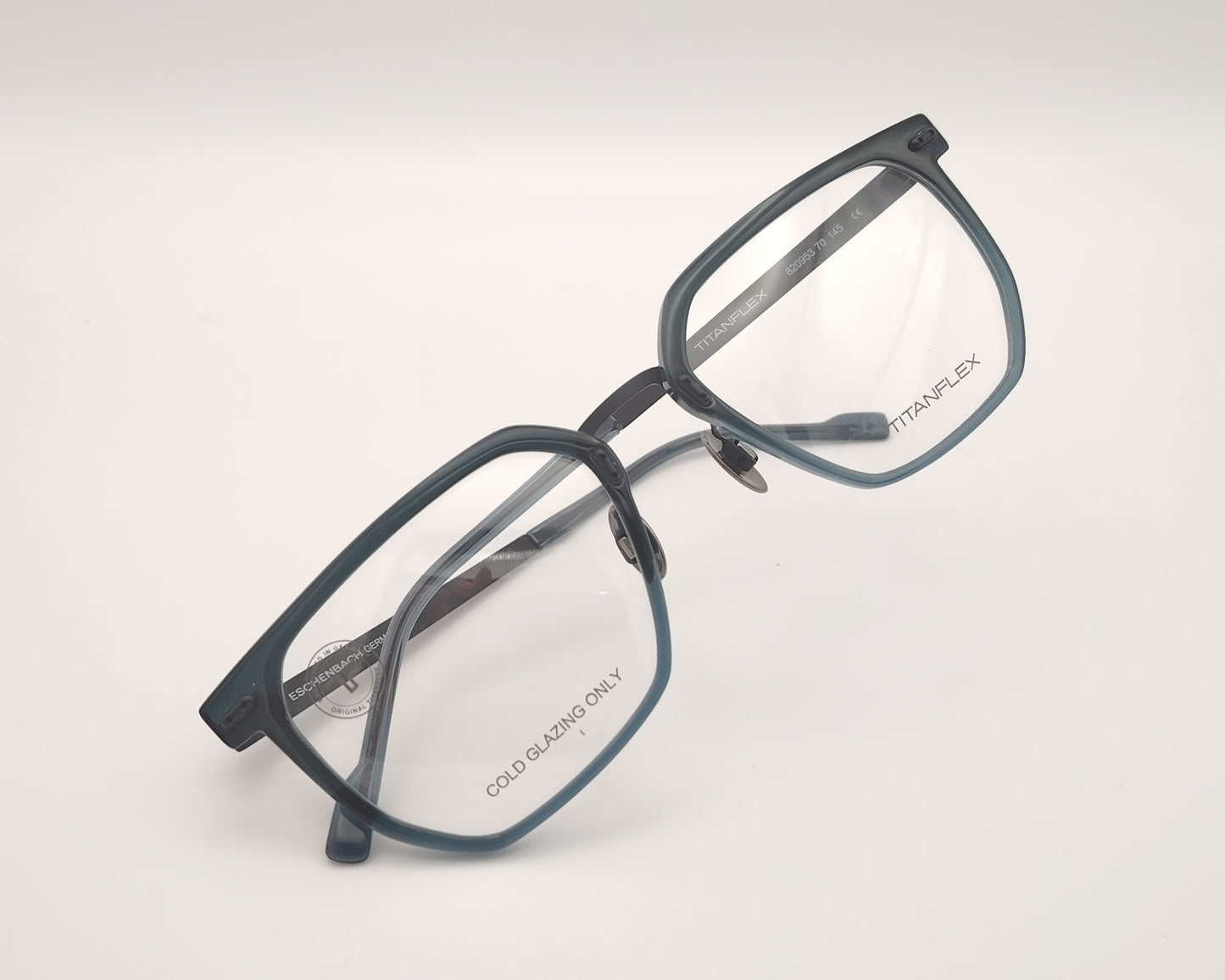 gafas titanflex cuadradas azul grisáceo translúcido con varillas metálicas negras