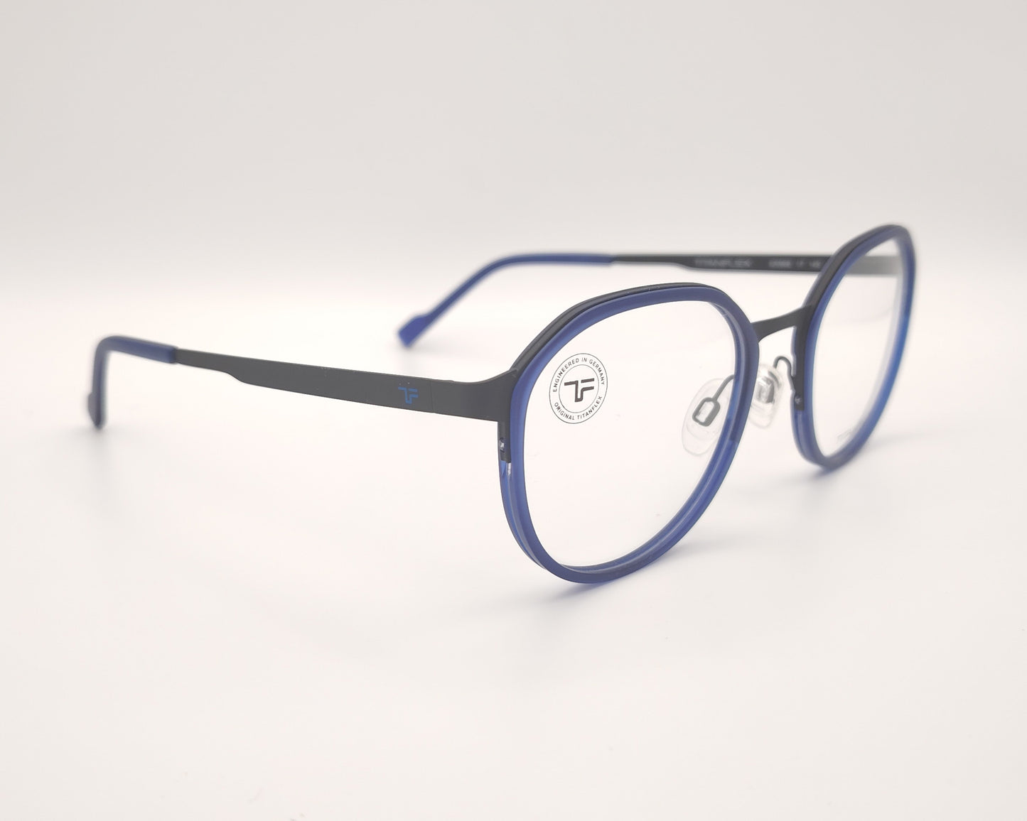 gafas titanflex redondas con frontal azul translúcido y varillas metálicas negras