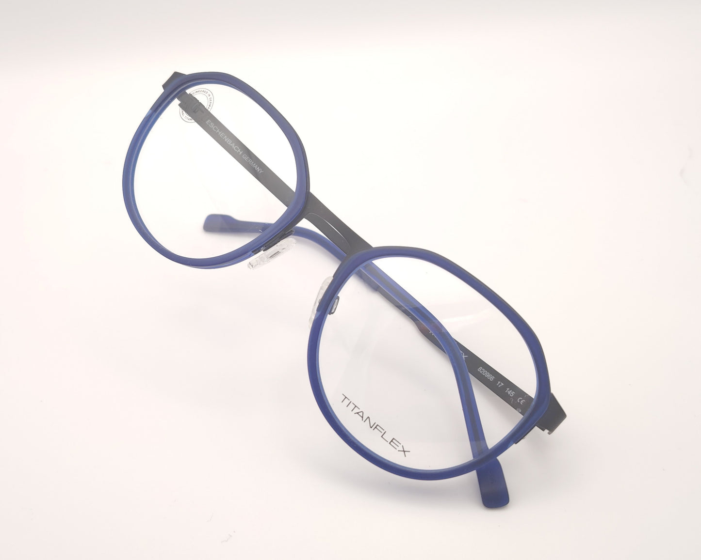gafas titanflex redondas con frontal azul translúcido y varillas metálicas negras