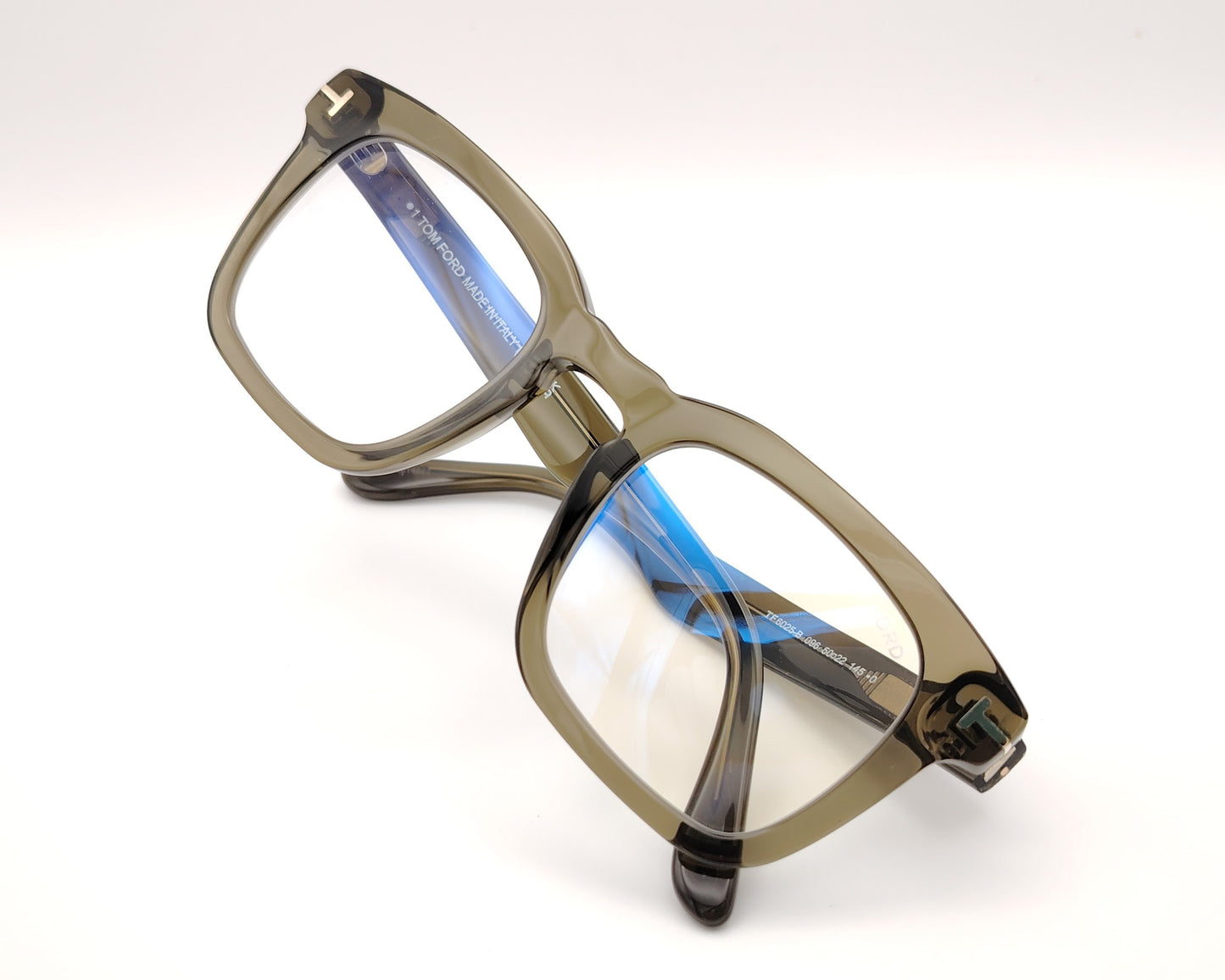 gafas de pasta verde translúcido con forma rectangular y detalle metálico en las patillas