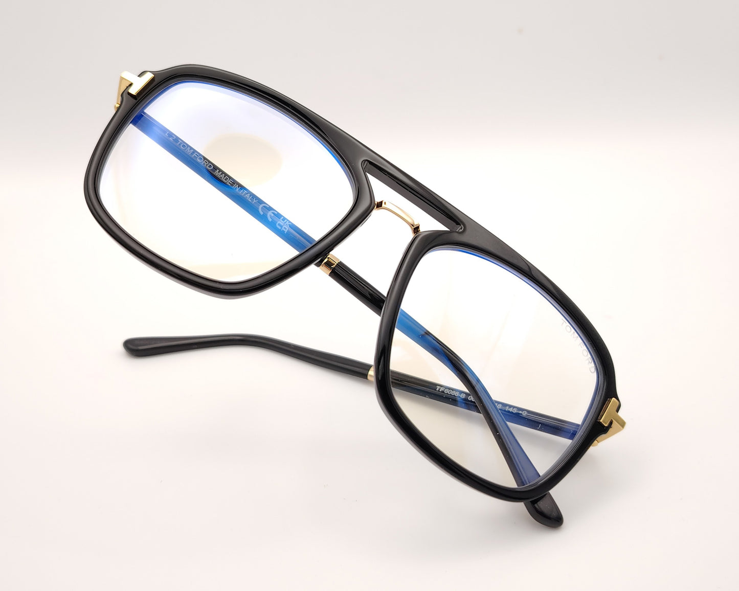 gafas tom ford negras con puente metálico y detalles dorados en frontal y patillas