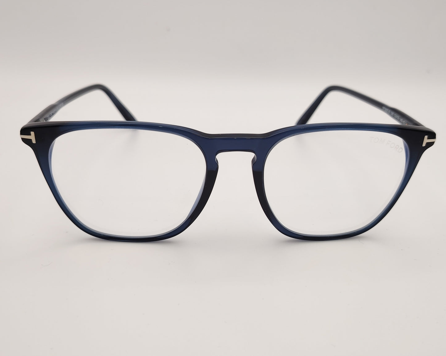 gafas graduadas con montura fina azul marino y detalle metálico en forma de T en las varillas