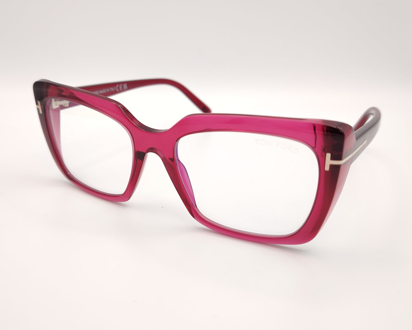 gafas graduadas con montura rectangular en acetato fucsia translúcido y detalle metálico dorado en forma de t en las varillas