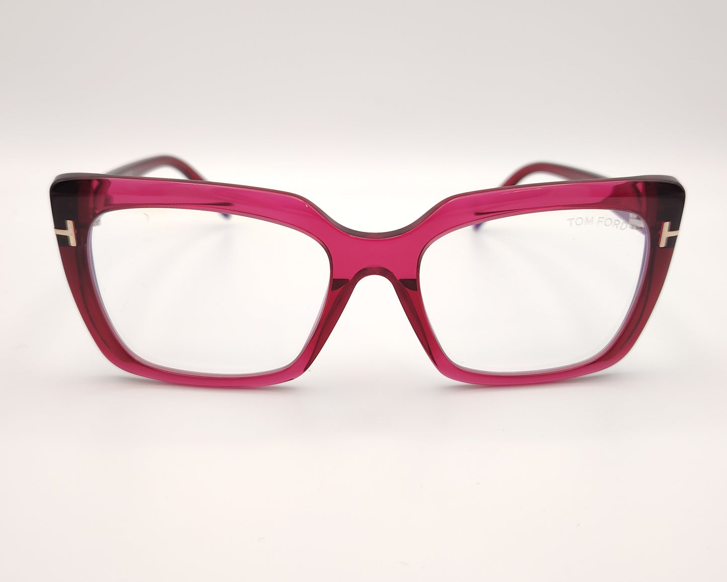 gafas graduadas con montura rectangular en acetato fucsia translúcido y detalle metálico dorado en forma de t en las varillas