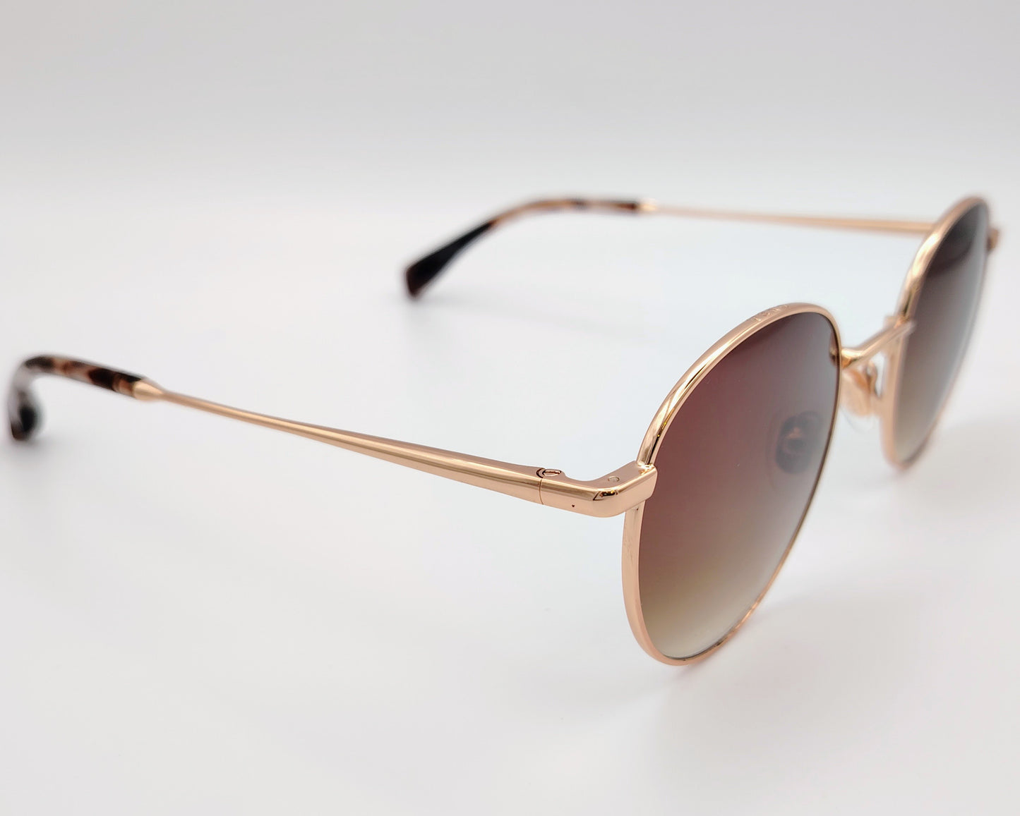 gafas de sol con montura metálica dorada y lentes redondas en degradado marrón