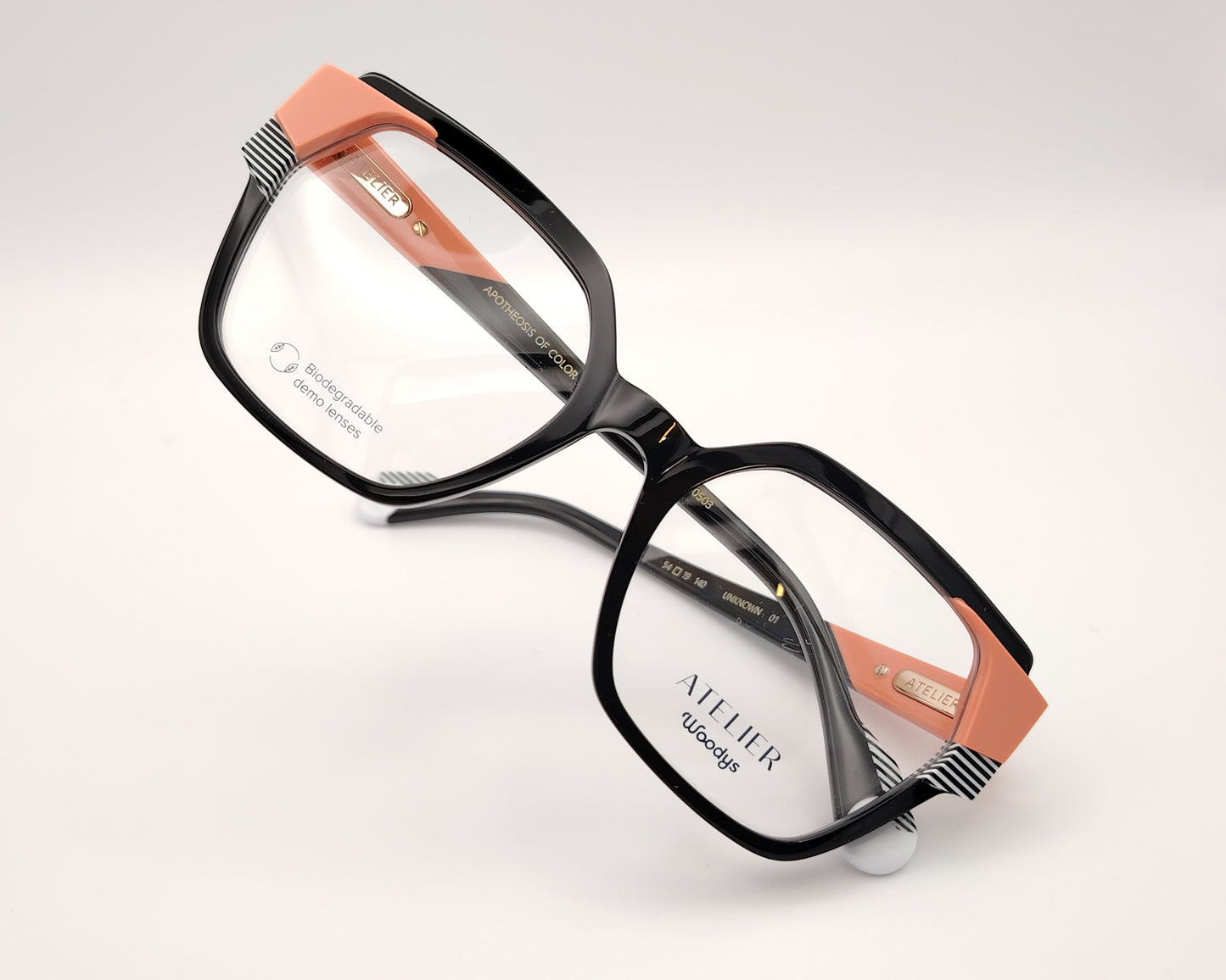 gafas graduadas woodys atelier unknown 01 de acetato negro con forma geométrica cuadrada y detalles arquitectónicos en color coral y rayas blancas y negras en las esquinas superiores y varillas