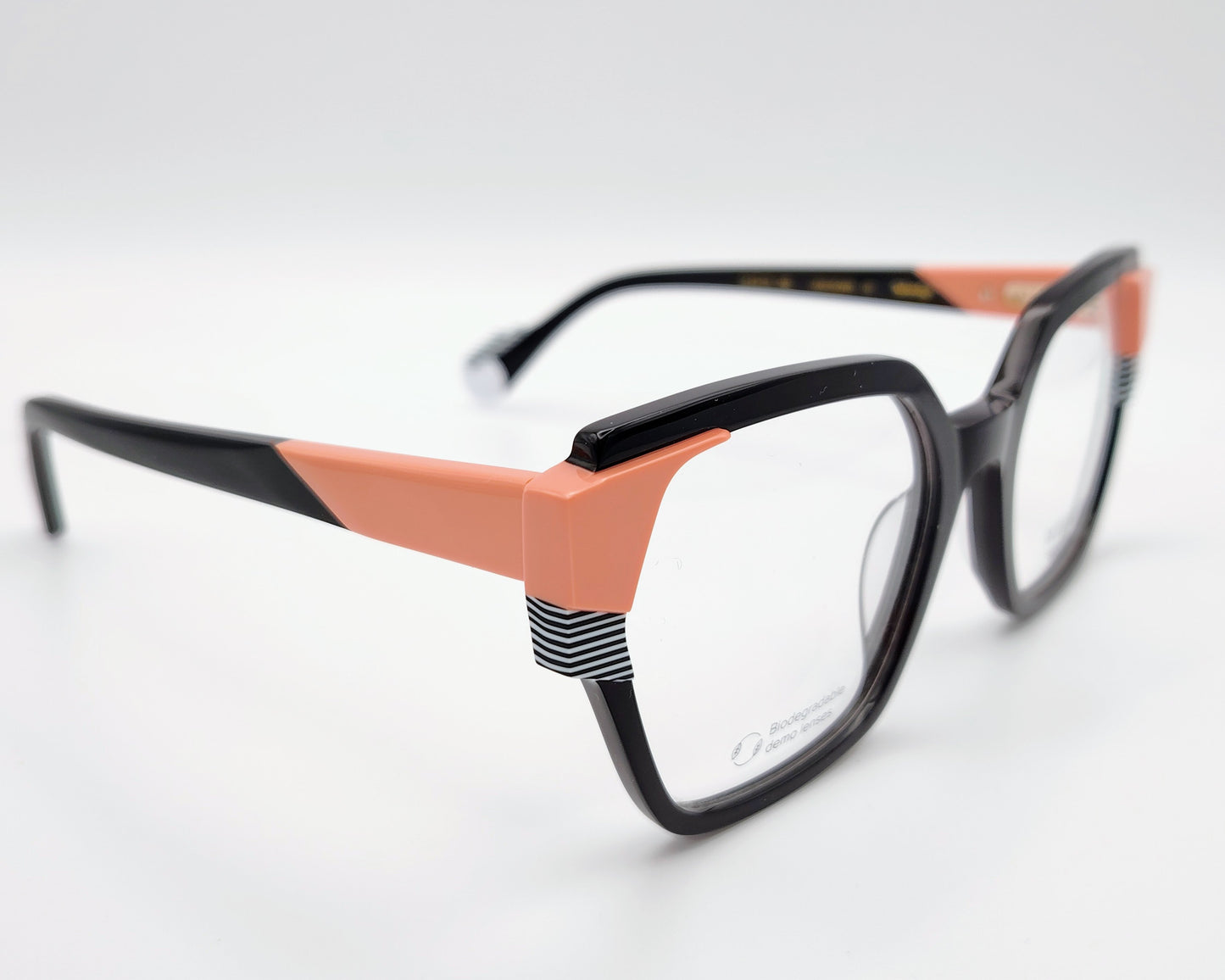 gafas graduadas woodys atelier unknown 01 de acetato negro con forma geométrica cuadrada y detalles arquitectónicos en color coral y rayas blancas y negras en las esquinas superiores