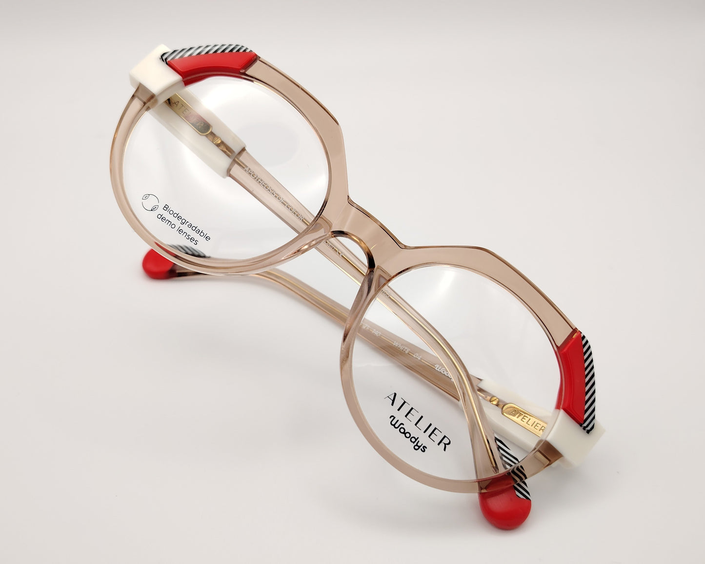 gafas graduadas woodys atelier white 04 de acetato nude traslúcido forma redonda detalles arquitectónicos en color blanco rojo y patrón de líneas en las esquinas superiores y varillas