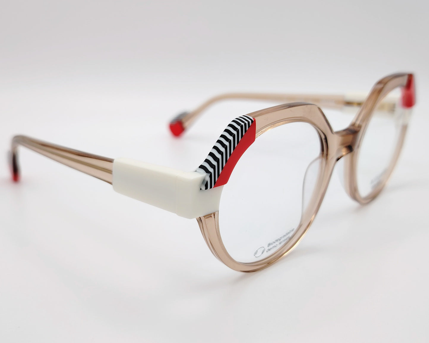 gafas graduadas woodys atelier white 04 de acetato nude traslúcido forma redonda detalles arquitectónicos en color blanco rojo y patrón de líneas en las esquinas superiores y varillas