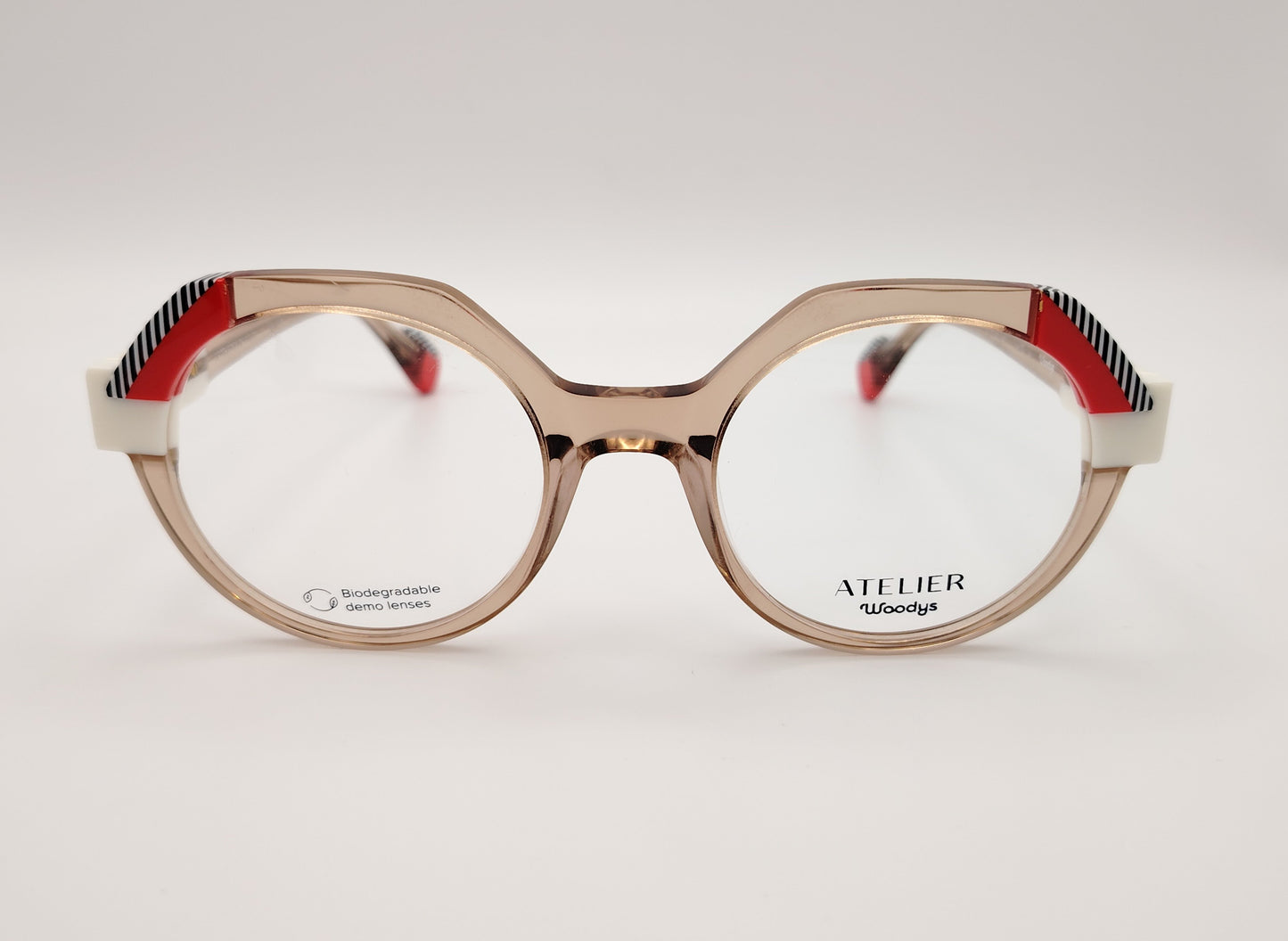 gafas graduadas woodys atelier white 04 de acetato nude traslúcido forma redonda detalles arquitectónicos en color blanco rojo y patrón de líneas en las esquinas superiores y varillas