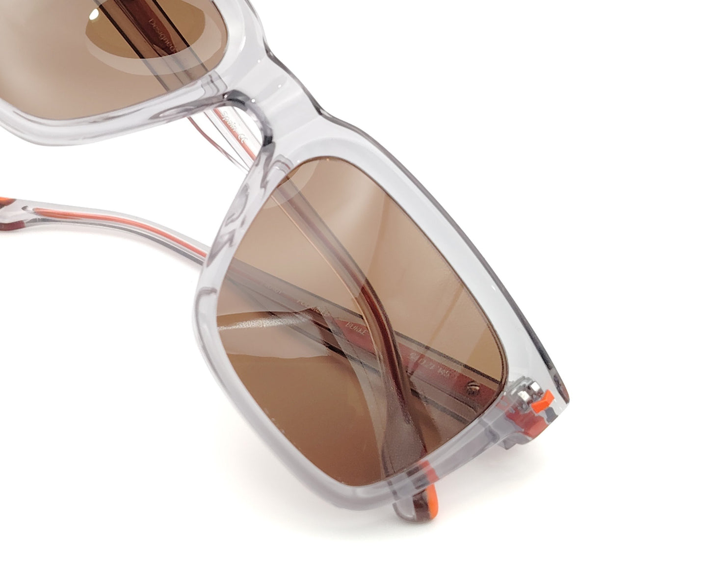 woodys burke 03 gafas de sol de forma rectangular con montura gris translúcida y detalles en naranja en las varillas y cristales polarizados marrones, diseño moderno ideal para un estilo urbano y actual