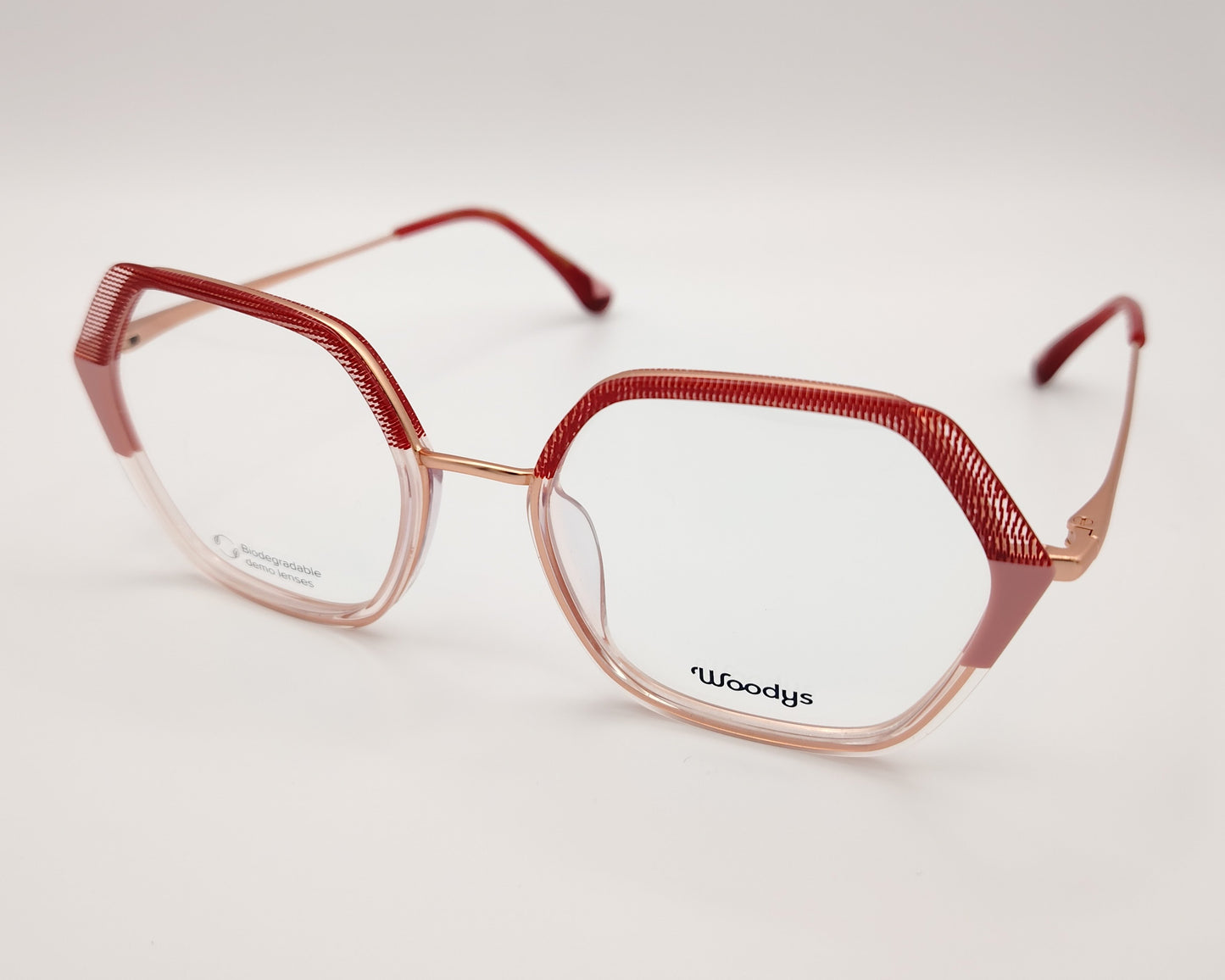 gafas graduadas woodys grazia 04 con montura geométrica de metal en tono dorado detalles texturizados en aro de acetato en color rojo y rosa en el frente y varillas diseño ligero y sofisticado