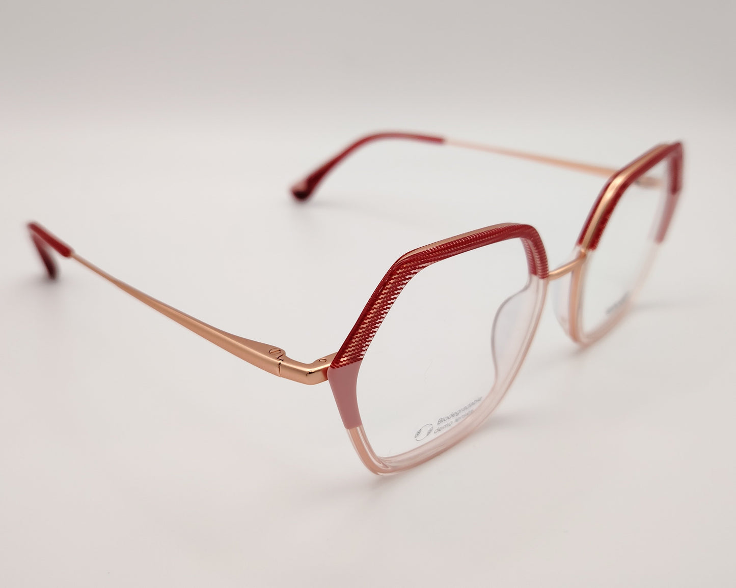 gafas graduadas woodys grazia 04 con montura geométrica de metal en tono dorado detalles texturizados en aro de acetato en color rojo y rosa en el frente y varillas diseño ligero y sofisticado