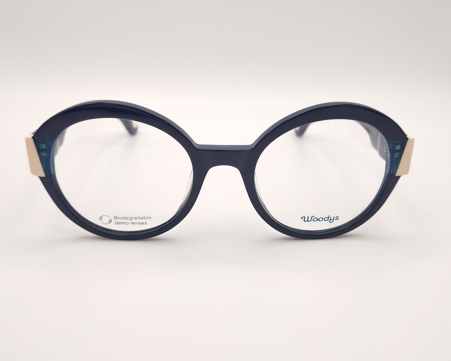 gafas graduadas woodys kilda 04 con montura de acetato en color azul marino diseño redondo con detalles geométricos en crema y texturas azuladas en las esquinas varillas en el mismo tono con sutiles detalles que aportan un estilo elegante y distintivo