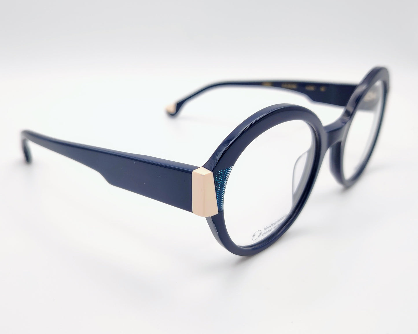 gafas graduadas woodys kilda 04 con montura de acetato en color azul marino diseño redondo con detalles geométricos en crema y texturas azuladas en las esquinas varillas en el mismo tono con sutiles detalles que aportan un estilo elegante y distintivo