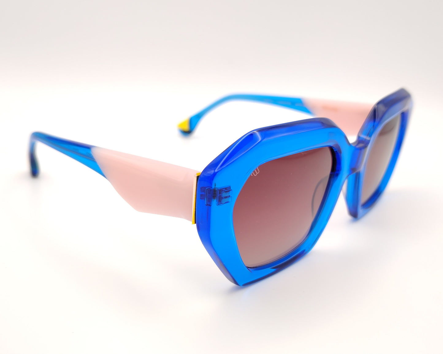 gafas de sol woodys meritxell 04 con montura oversize de acetato azul translúcido diseño geométrico con detalles en rosa y amarillo lentes degradadas en tono marrón varillas con contraste de color