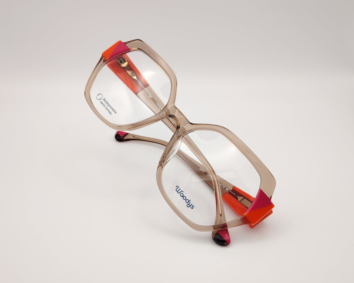 gafas woodys savoye 04 montura geométrica nude translúcido detalles naranja y fucsia diseño moderno y atrevido