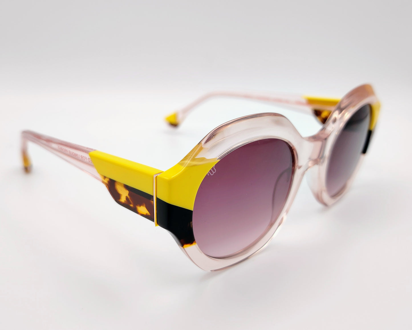 gafas de sol woodys valeria 06 con montura de acetato transparente diseño redondeado con detalles en amarillo y carey en las esquinas lentes degradadas en tono rosado