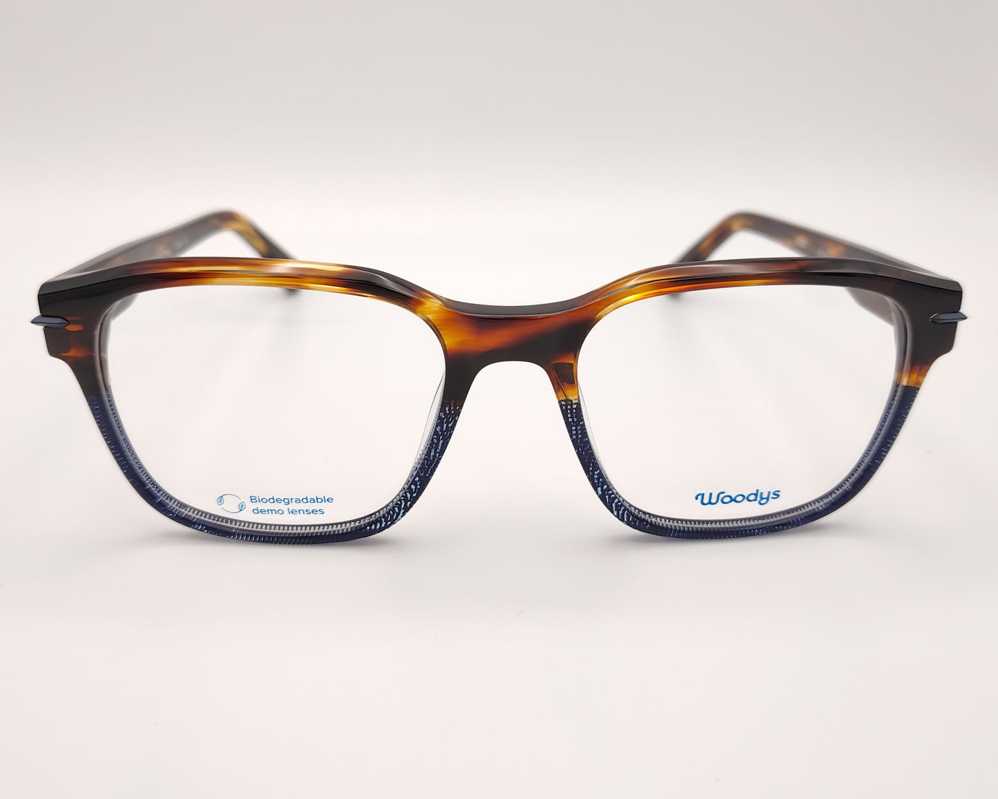 gafas graduadas woodys verne 02 con montura de acetato en tono habana combinada con detalles en azul diseño rectangular con sutil textura en la parte inferior que añade un toque moderno varillas en el mismo tono con detalles metálicos en el interior