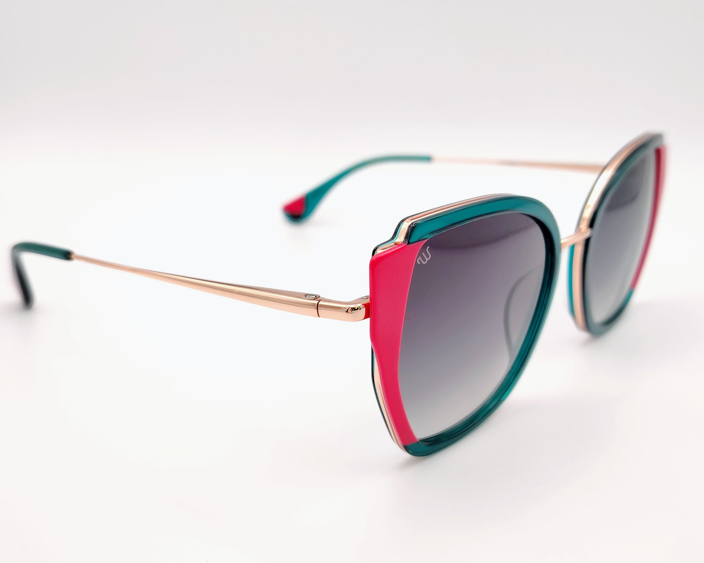 gafas de sol woodys vittoria 03 con montura geométrica con estructura en metal dorado y aro en acetato verde y detalles en rosa diseño llamativo con lentes degradadas en gris y varillas finas